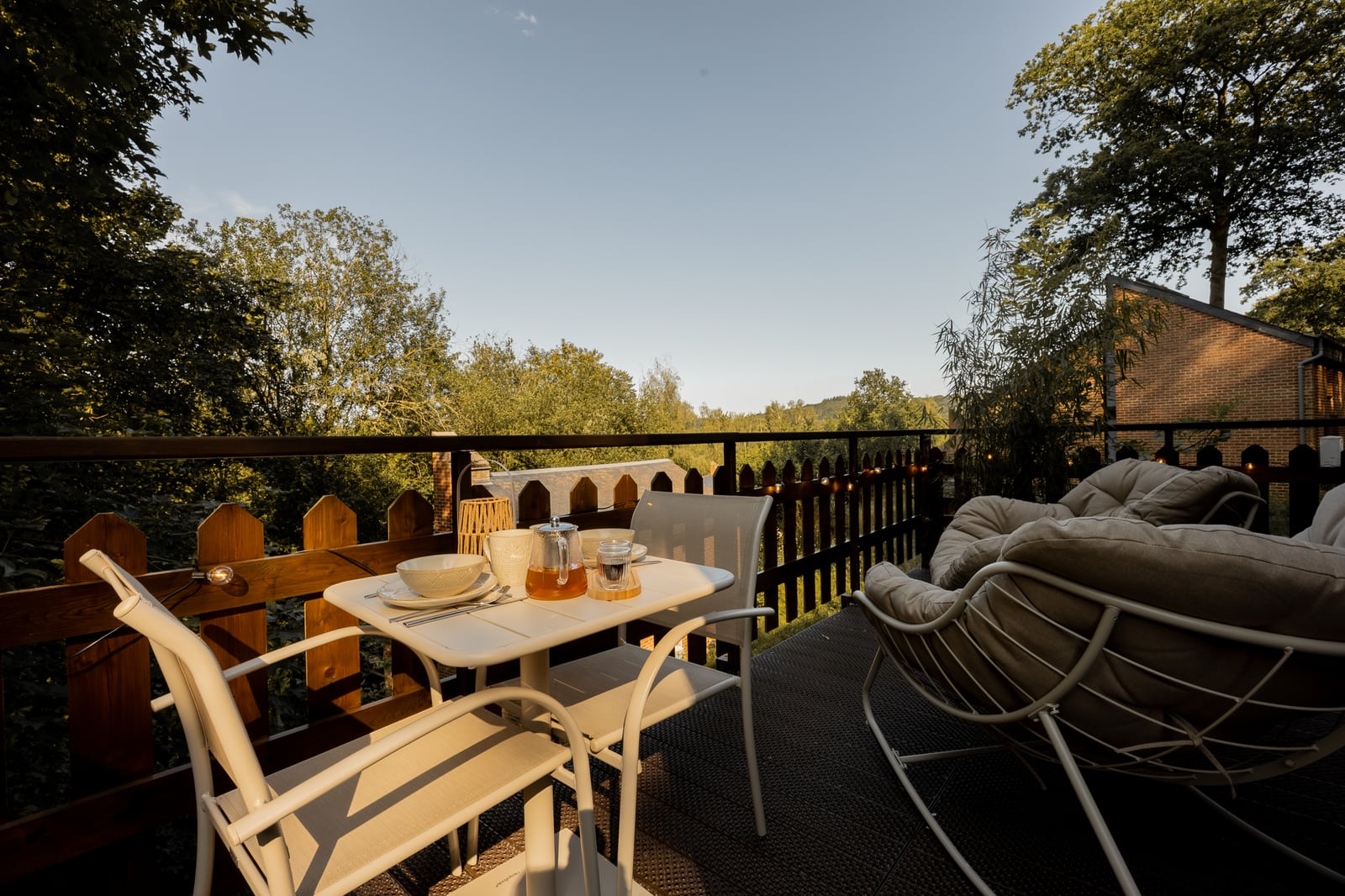 Terrasse aménagée avec table pour deux, fauteuils et vue sur la vallée